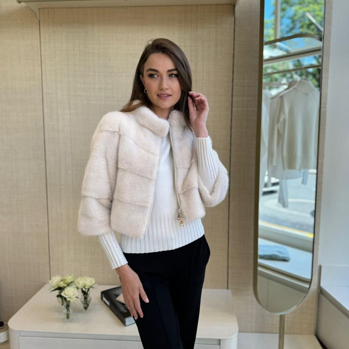 Woman wearing a white fur coat in a store setting
