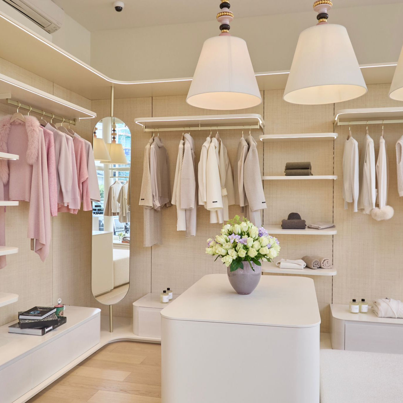 Modern clothing store interior with racks of clothes and a display table.