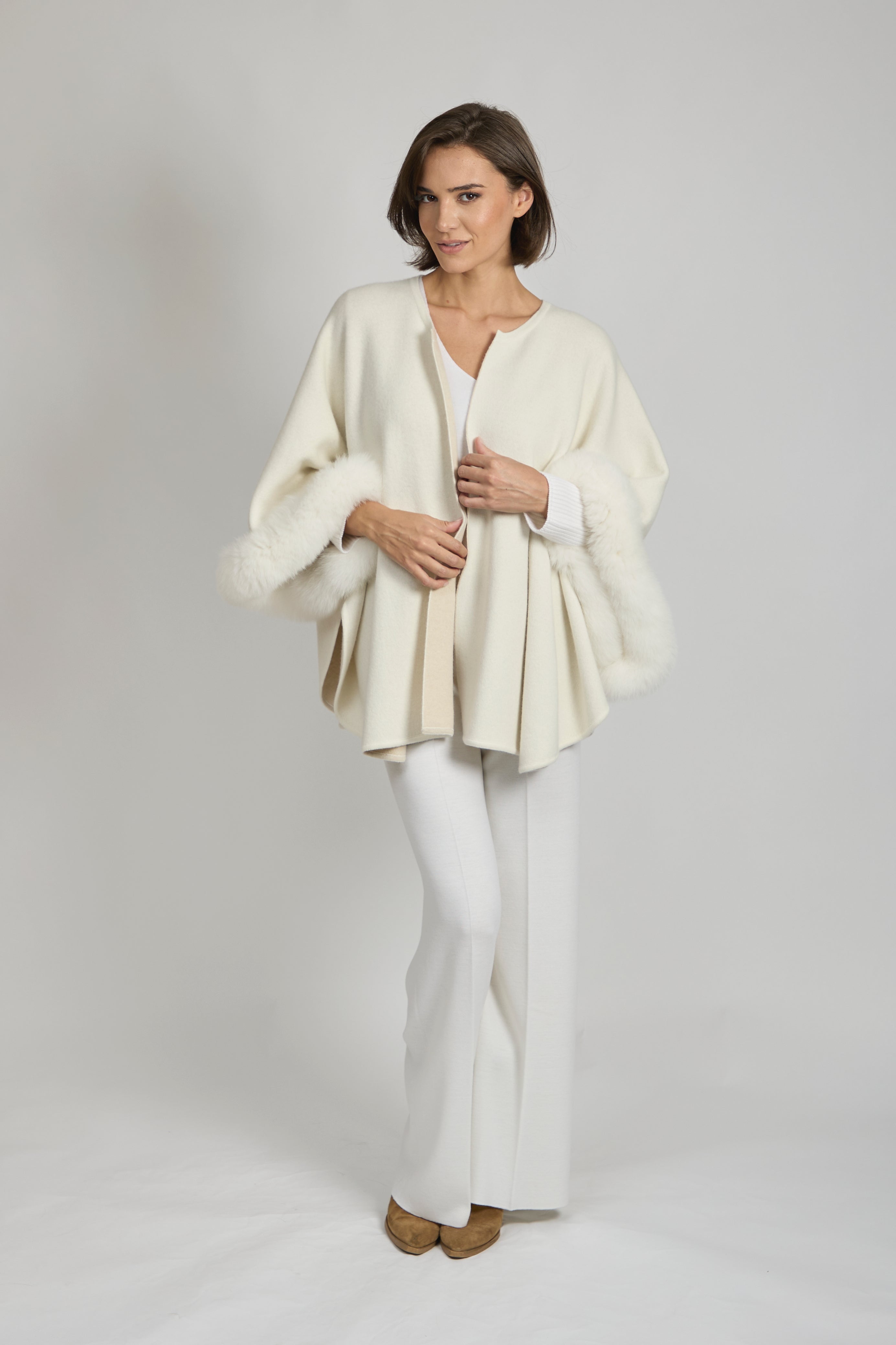 Divine Cashmere reversible cape in cashmere with fox fur trim and structured shoulders.